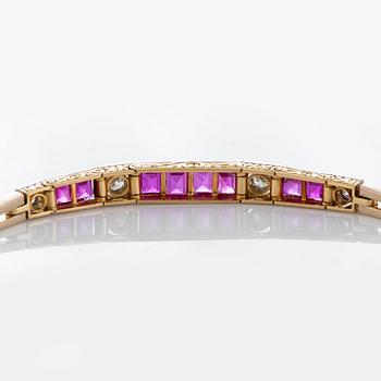 An 18K gold and platinum bracelet set with step-cut rubies and old- and rose-cut diamonds.