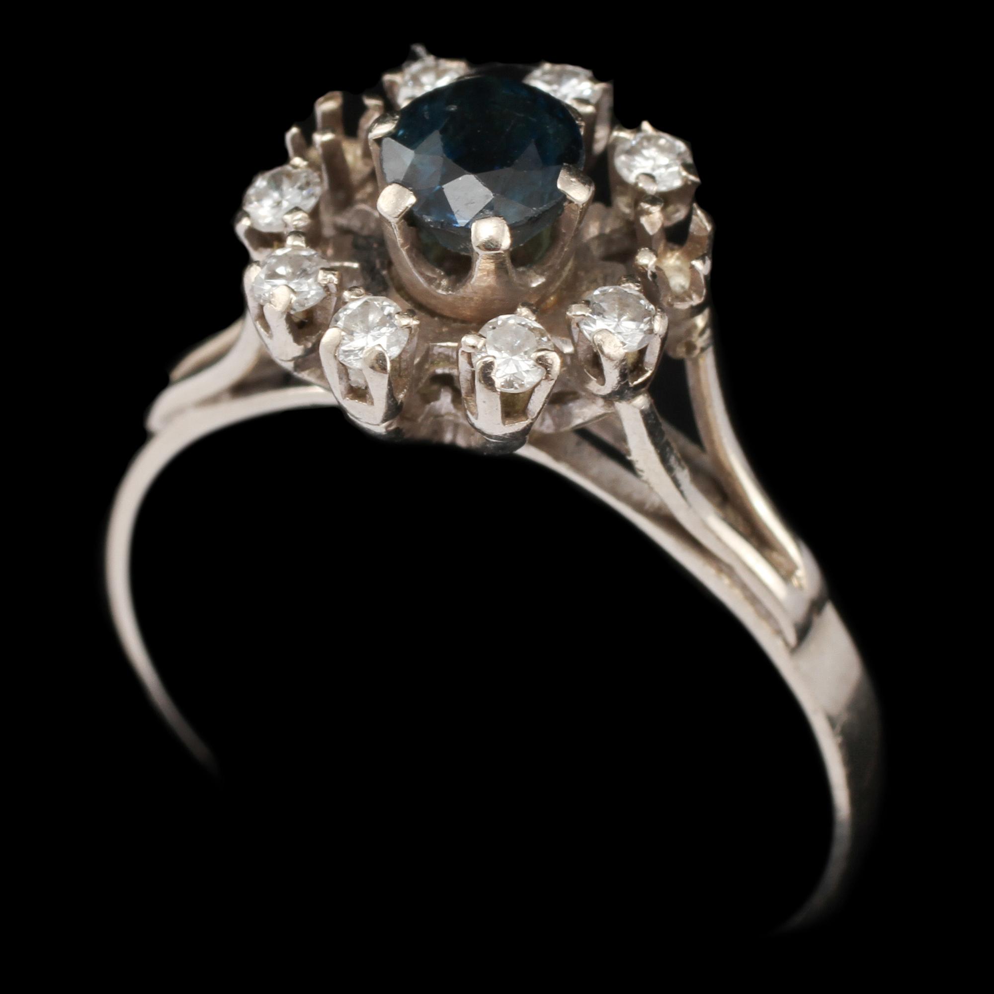 RING, 18k vitguld med fasettslipad blå safir samt 8 briljantslipade diamanter, 1900-talets tredje kvartal. Vikt 4 g.