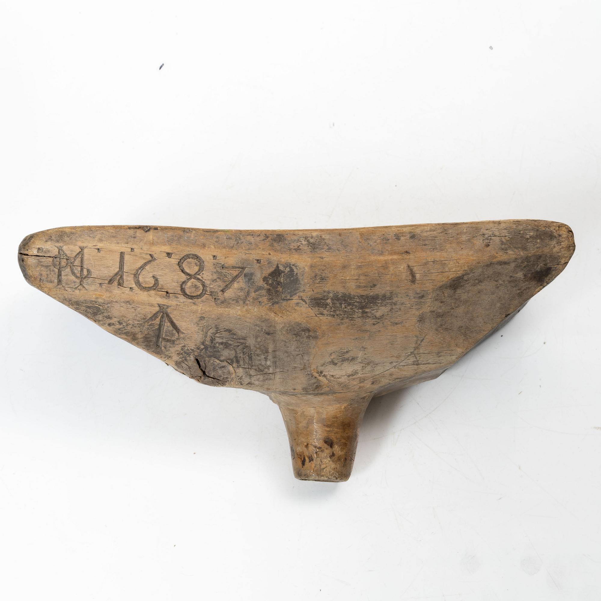 A Swedish carved wood milk funnel, dated 1687.