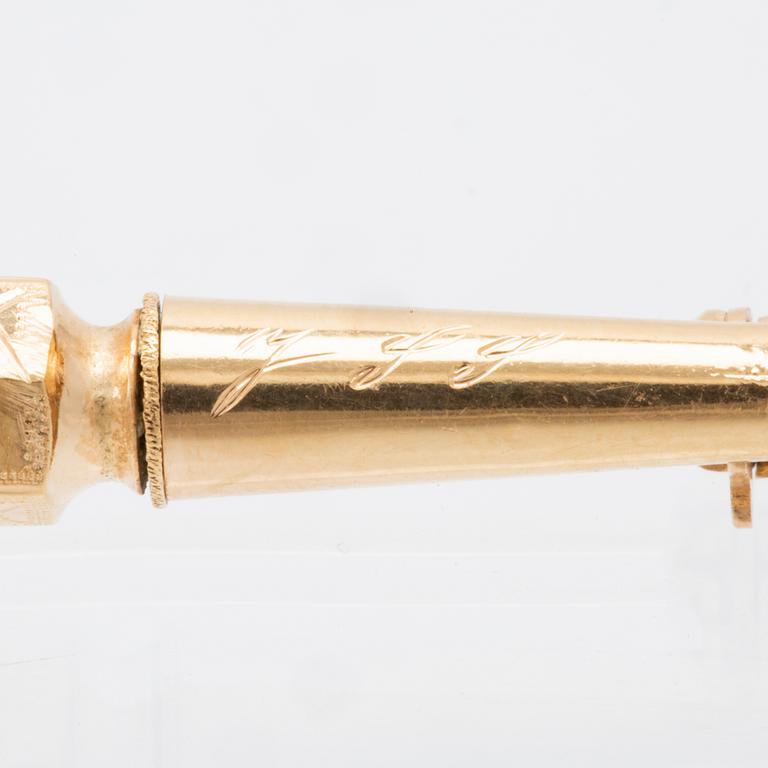 An 18K gold brooch set with a synthetic ruby.