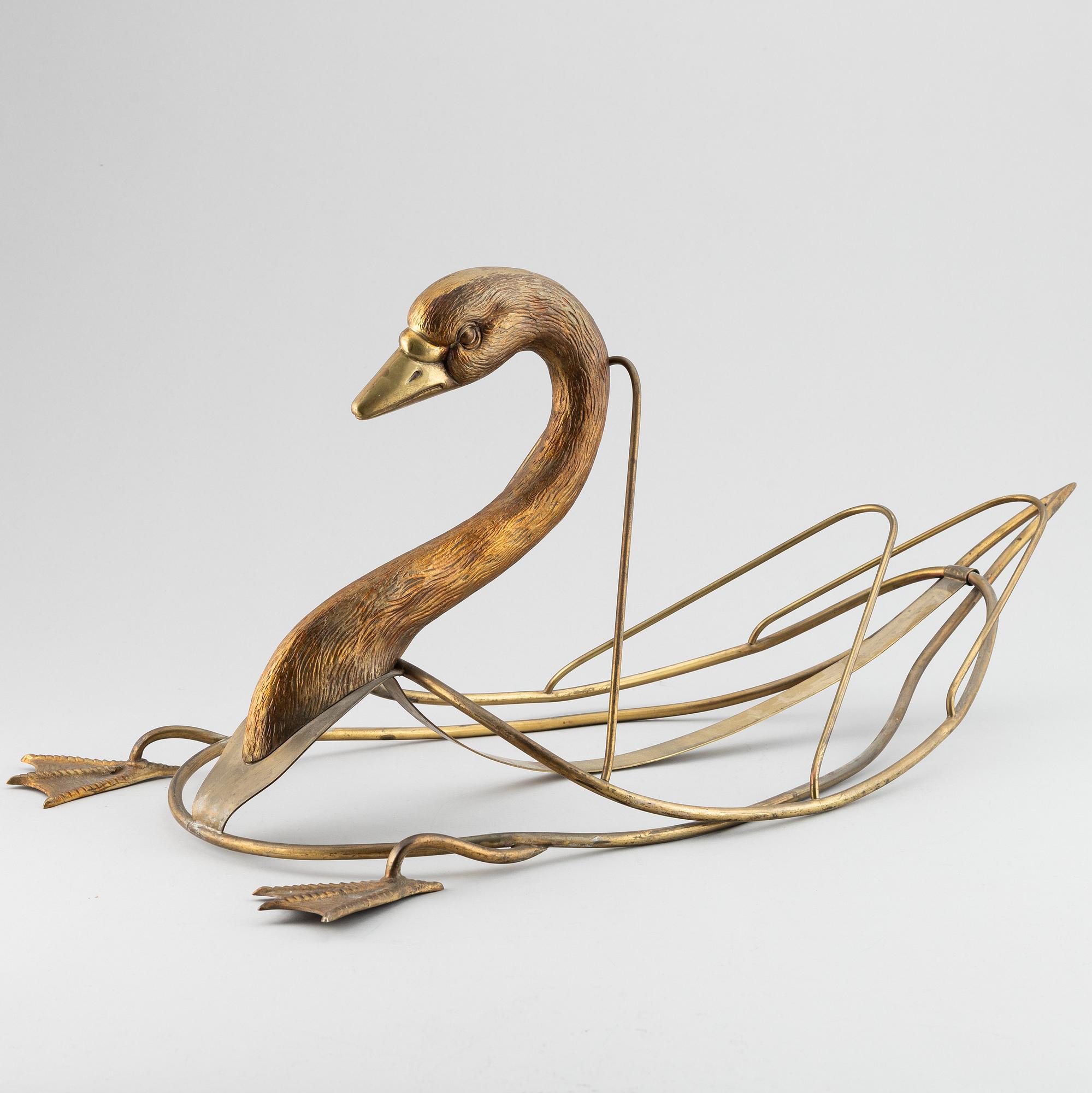 A 20th century grass newspaper stand in the shape of a swan.