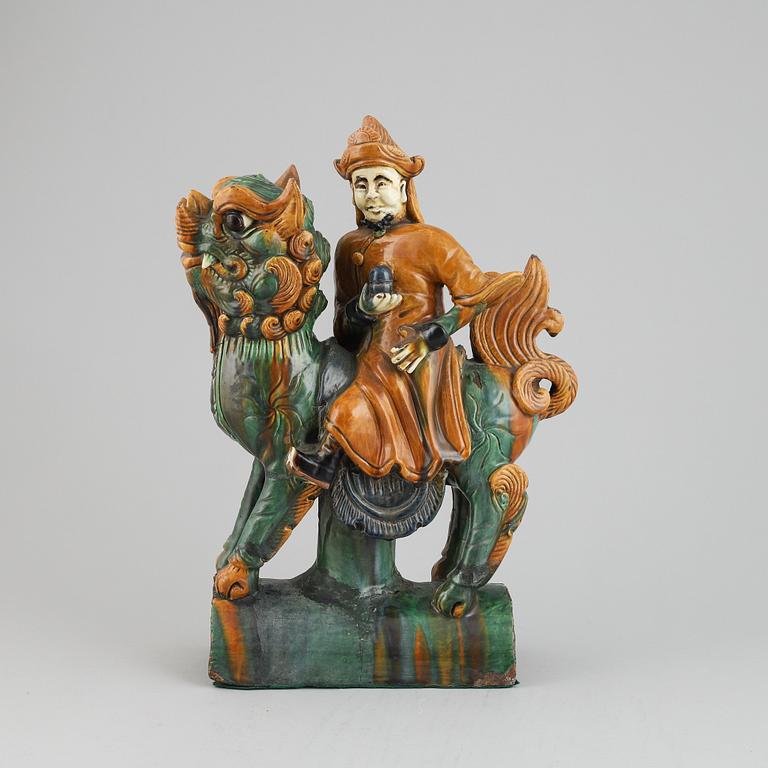 A Chinese sancai glazed stoneware roof tile in the form of a dignitary on a buddhist lion,  Mingdynasty (1368-1644).