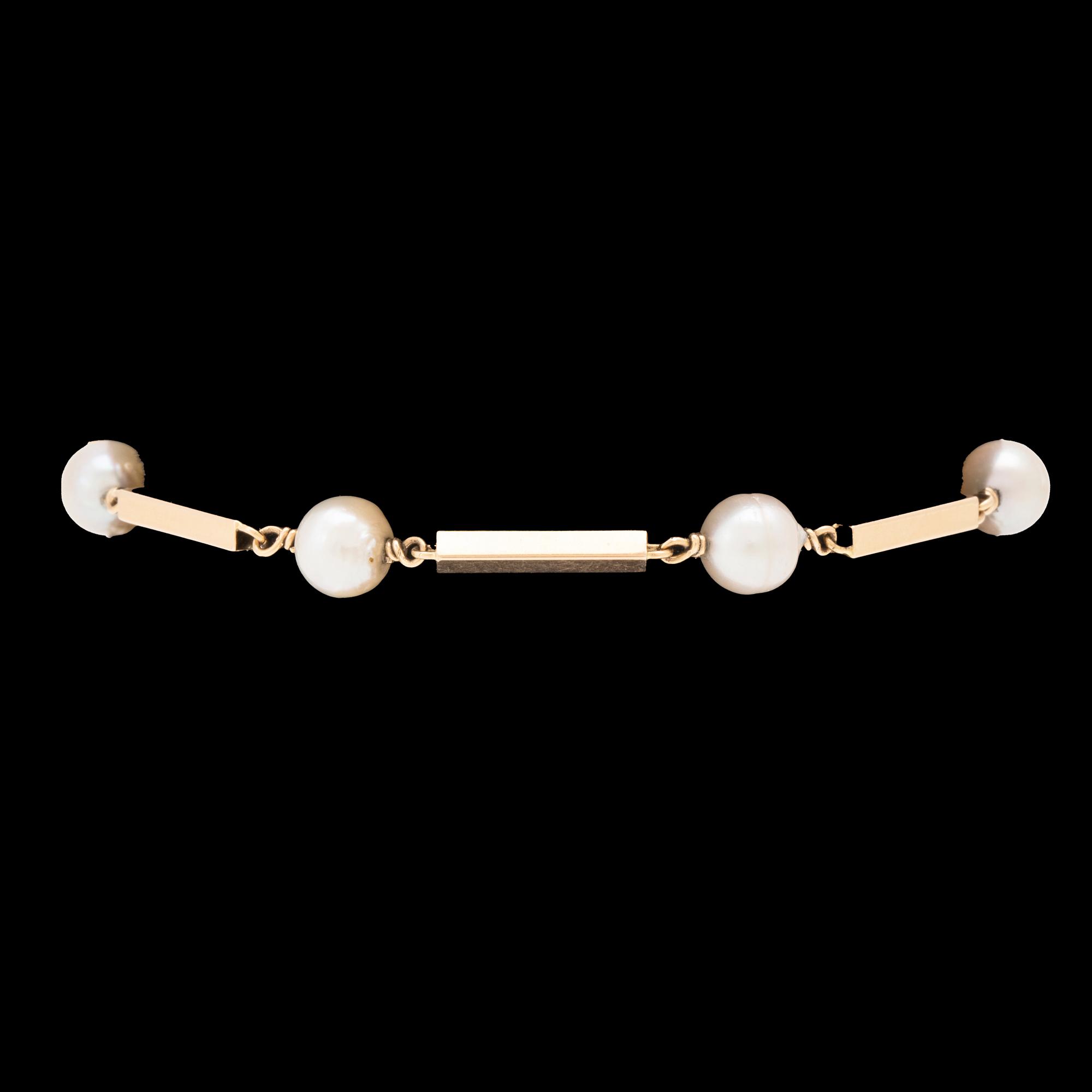 An 18K gold bracelet set with cultured pearls.