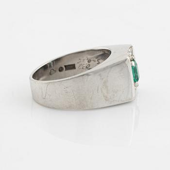 An 18K white gold ring set with a step-cut emerald and round brilliant-cut diamonds.