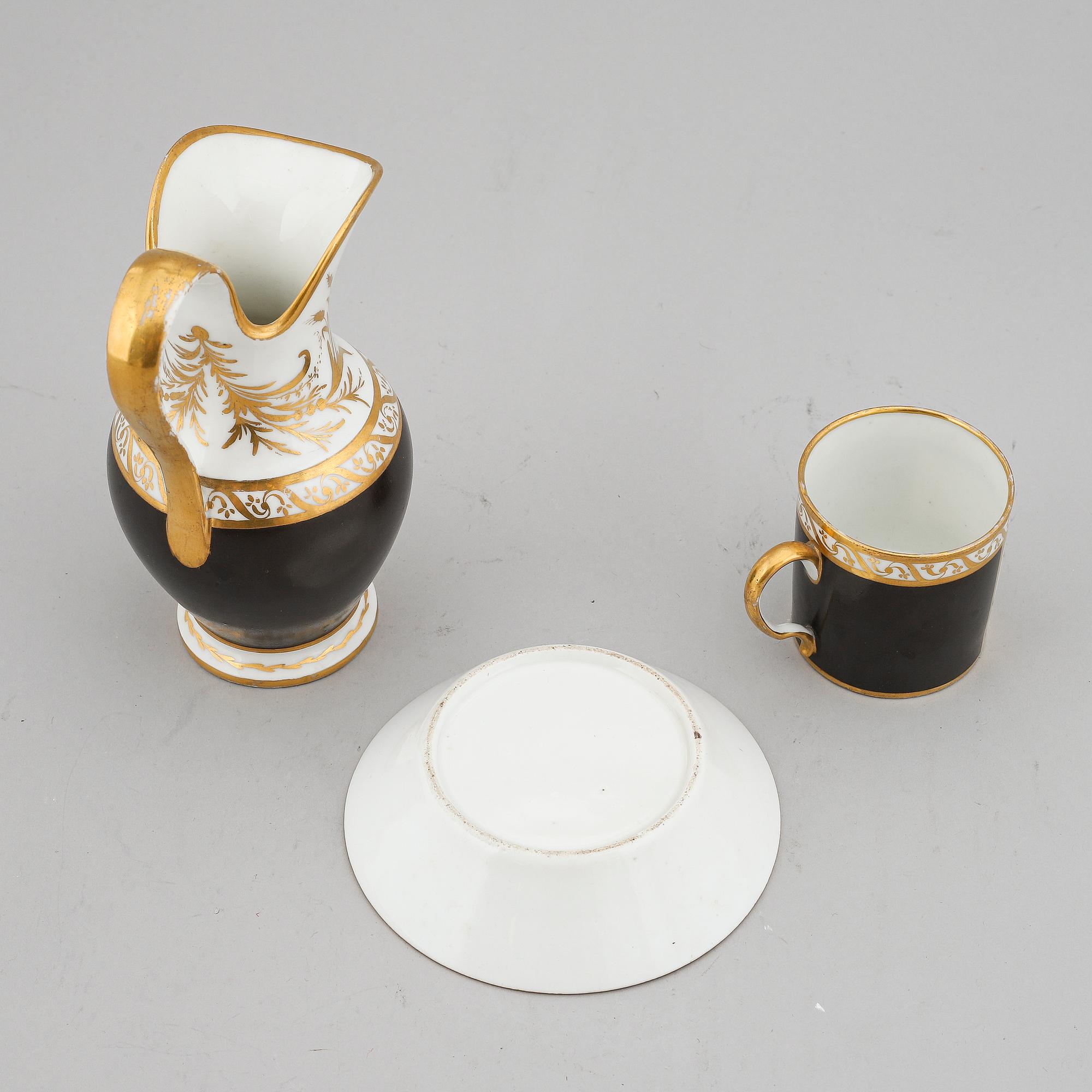 A porcelain jug and a cup with saucer, empire style, circa 1900.