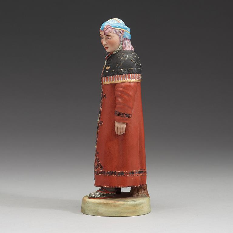 A Russian bisquit figure depicting a Khanty woman, Kusnetsov, first half of 20th Century.