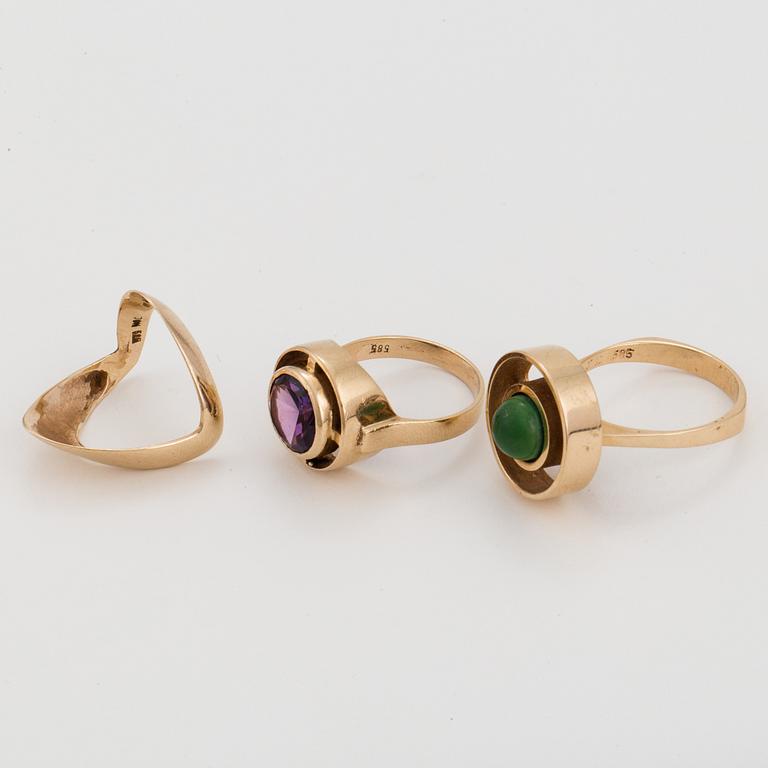 Three 14K gold rings, one with a synthetic, colour-change, sapphire and one with a green stone.