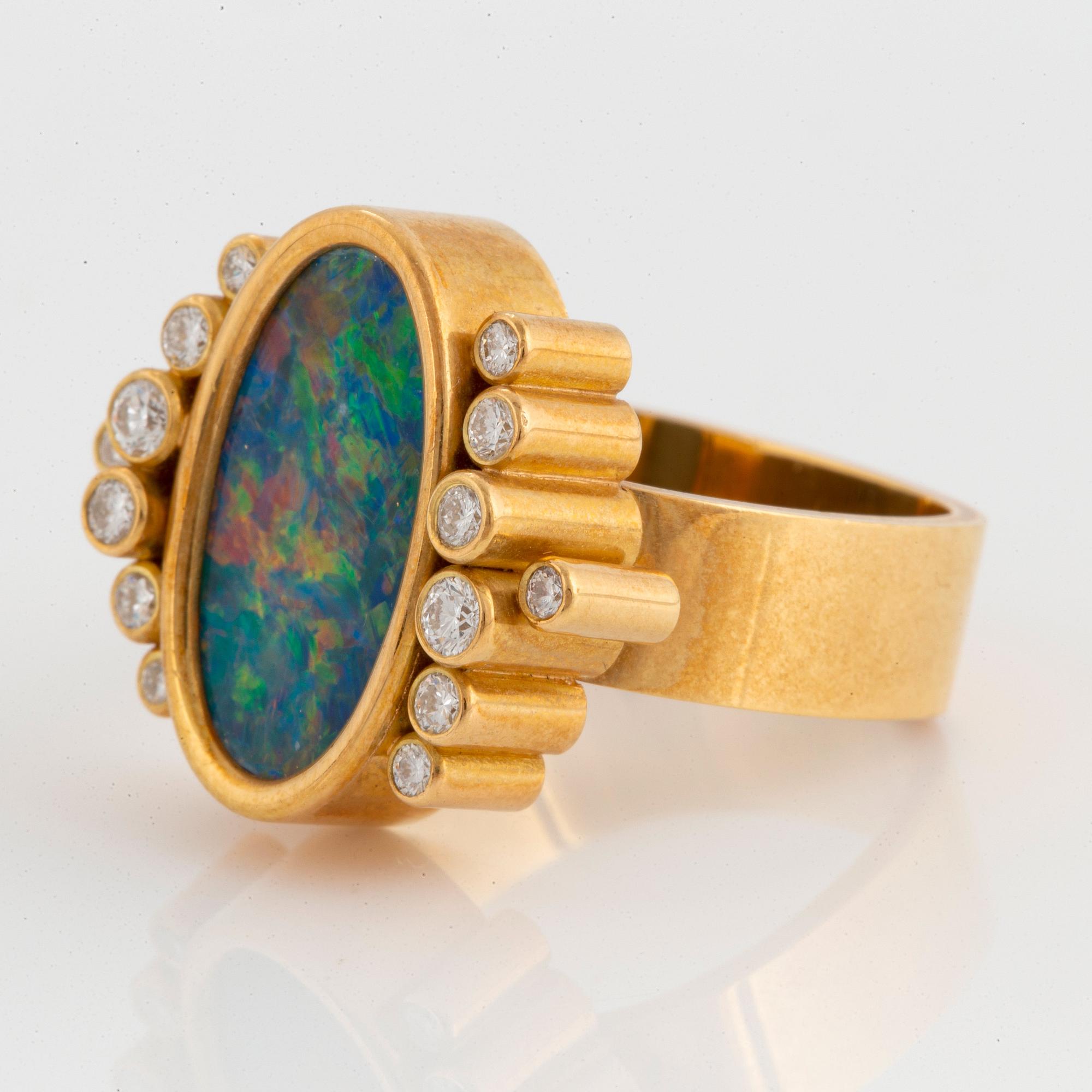 An 18K gold and opal ring set with round brilliant-cut diamonds.