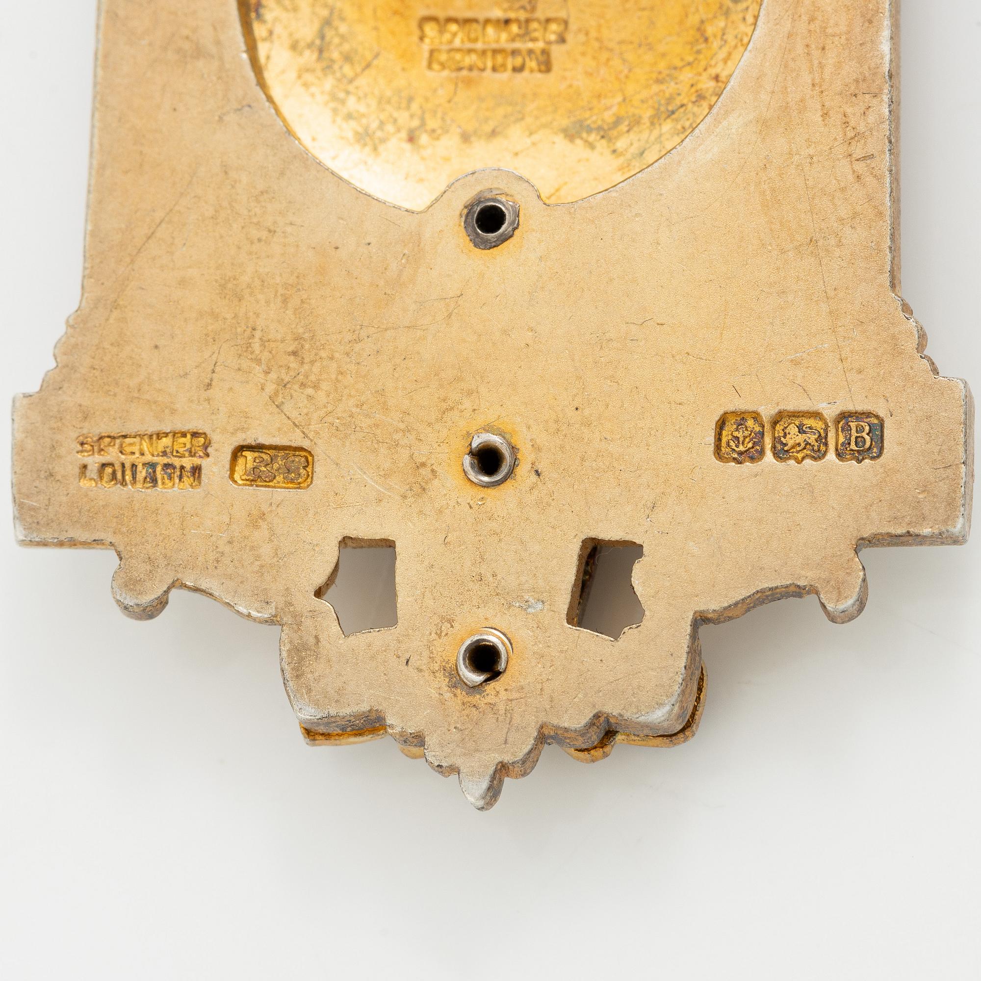 A jeton and pin, in gilded silver and 9 ct gold respectively.