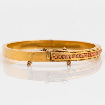 An 18K gold bracelet set with coral.