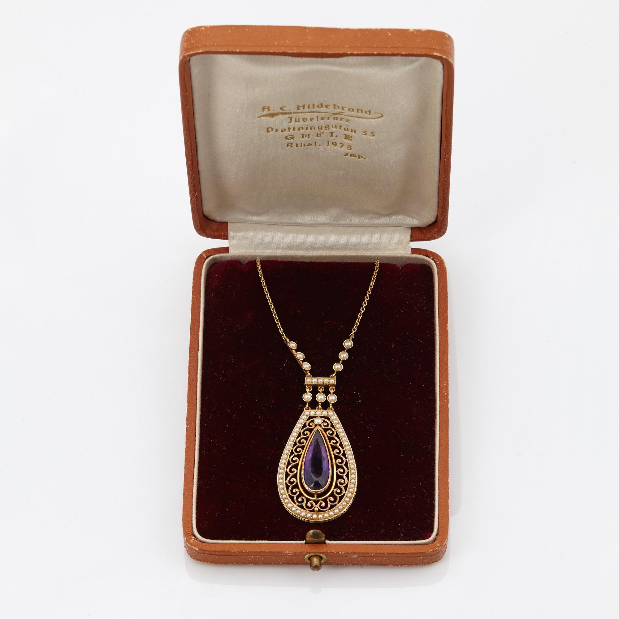 A 14K gold necklace set with a faceted amethyst and pearls.