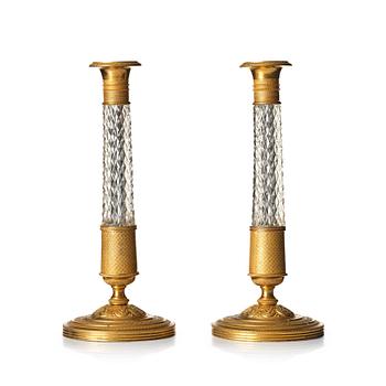 A pair of French gilt bronze and cut-glass Empire-style candlesticks, later part of the 19th century.