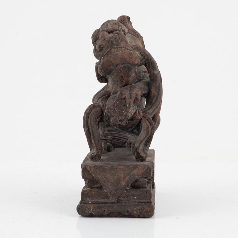 A stone sculpture of a mythical creature and four textile fragments, Qing dynasty.