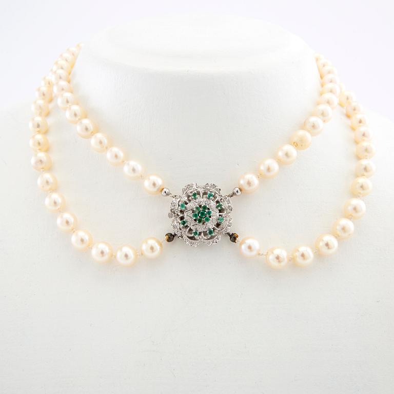 Necklace double-stranded of cultured pearls with a clasp of 18K white gold and emeralds.