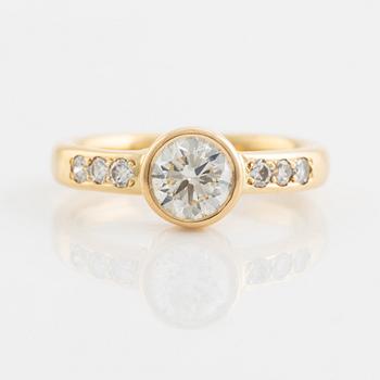 An 18K gold ring set with a round brilliant-cut diamond.