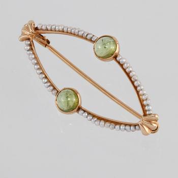 BROSCH, 18K guld med 2 cabochonlipade peridoter samt små odlade pärlor, Engelbert, Stockholm, 1956. Vikt 2,8 gram.