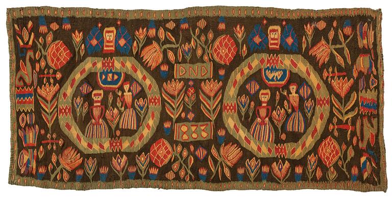 A carriage cushion, "the Annunciation", tapestry weave, ca 103 x 51 cm, south western Scania (Sweden), 1833.