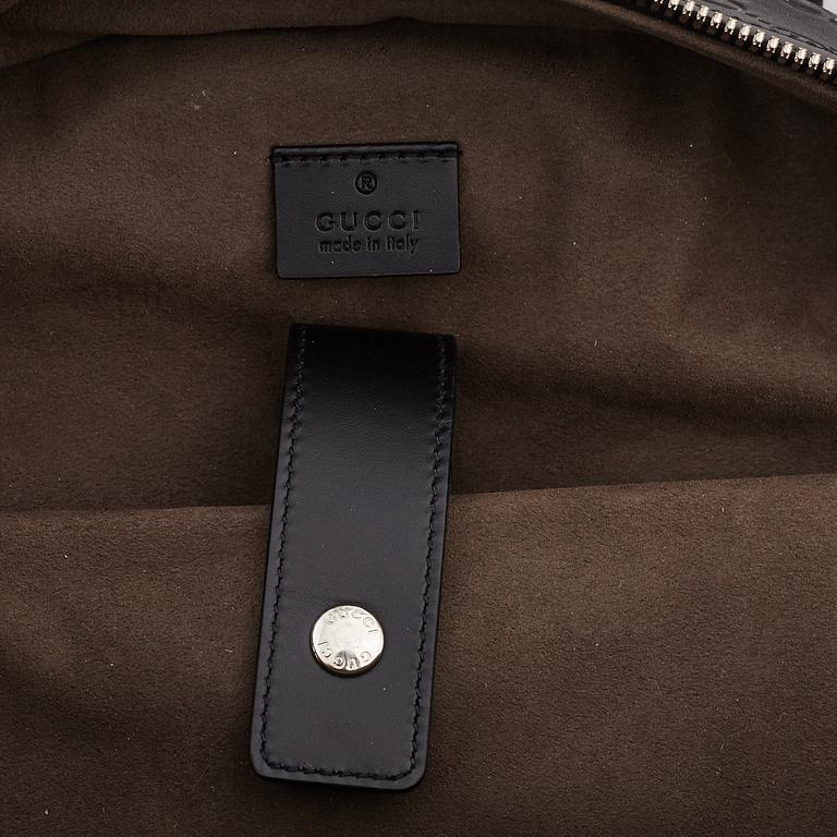 GUCCI, a black leather backpack.