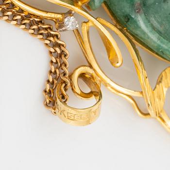 Pendant in gold with a carved green stone, adorned with brilliant-cut diamonds.