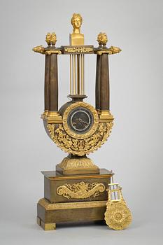 A French Empire early 19th century patinated and gilt bronze mantel clock.