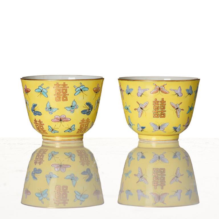 A pair of yellow glazed double happiness cups with butterflies, Qing dynasty, with Tongzhis four character mark to base.