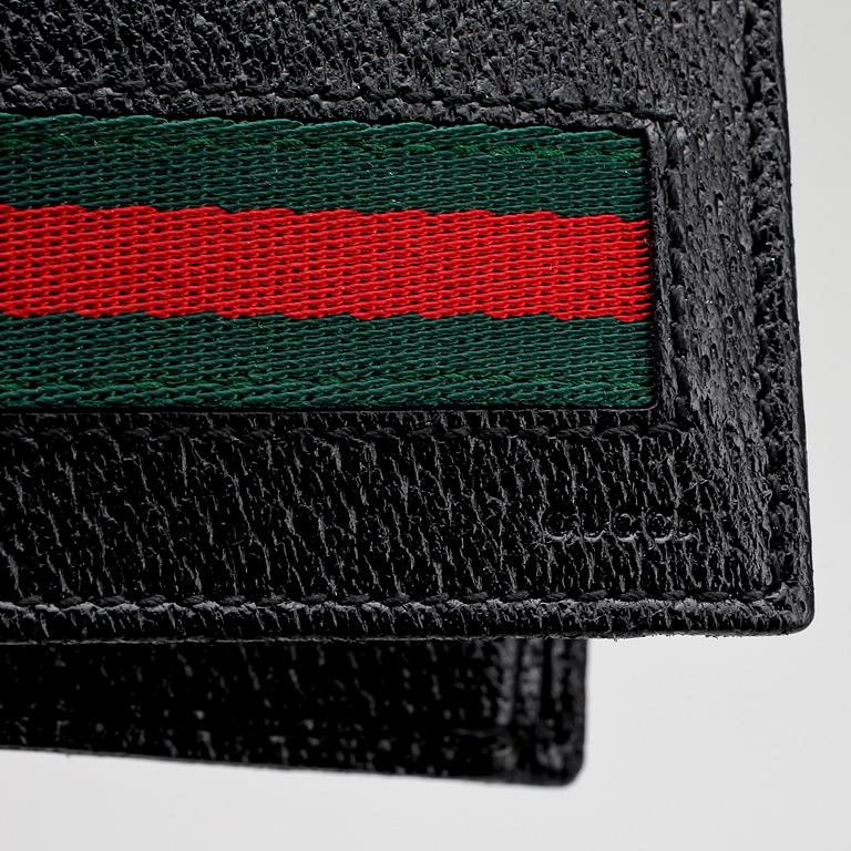 GUCCI, a black leather wallet.