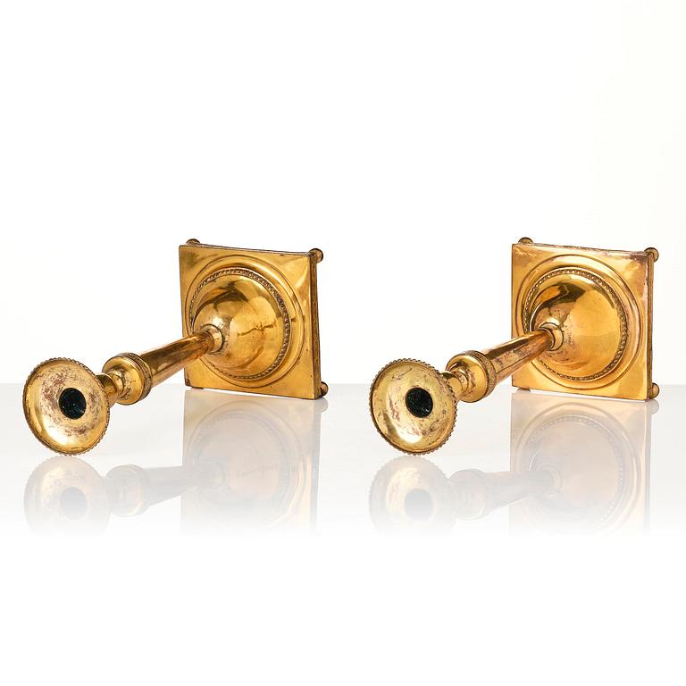 A pair of late George III gilt-copper candlesticks, early 19th century.