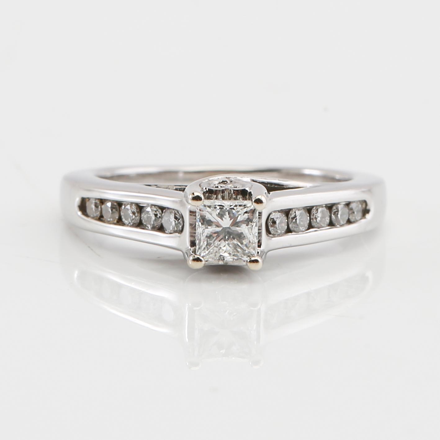Ring in 14K white gold with a princess cut and round brilliant cut diamonds.