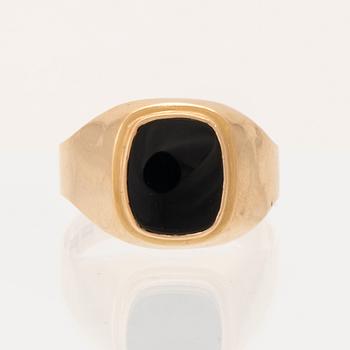 An 18K gold ring set with a black stone.