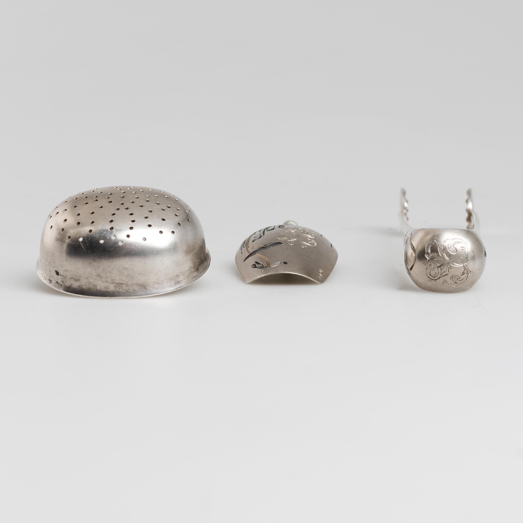 A Russian parcel-gilt tea caddy spoon, sugar thongs and sugar sifter, maker's mark Grigory Spitnev, Moscow, 1898-1914.