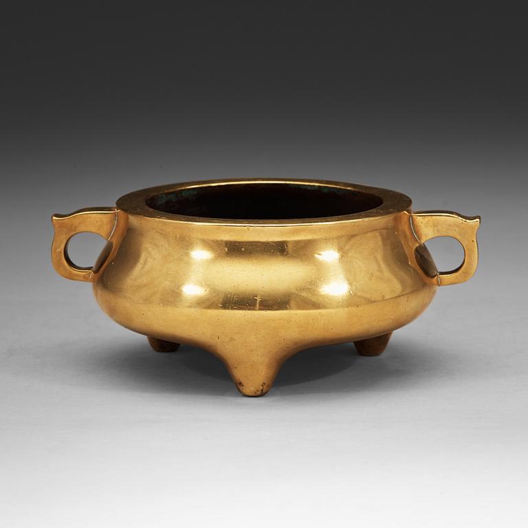 A polished bronze tripod censer, Ming dynasty (1368-1644).