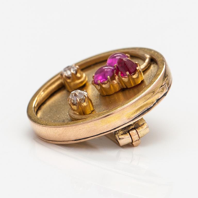 A 14k gold brooch with diamonds ca. 0.12 ct in total and rubies, of which one is synthetic.