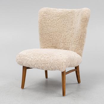 A mid 20th Century easy chair with sheepskin upholstery.