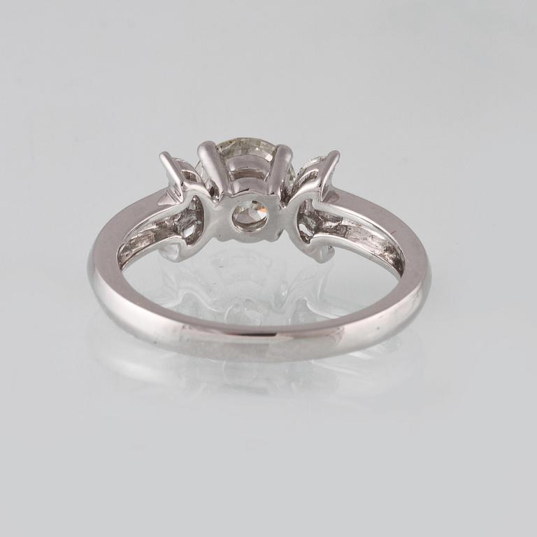 RING, 18K vitguld med briljantslipad diamant ca 1.11 ct samt 6 navetteslipade diamanter 0.26 ct. Vikt 4,2 gram.