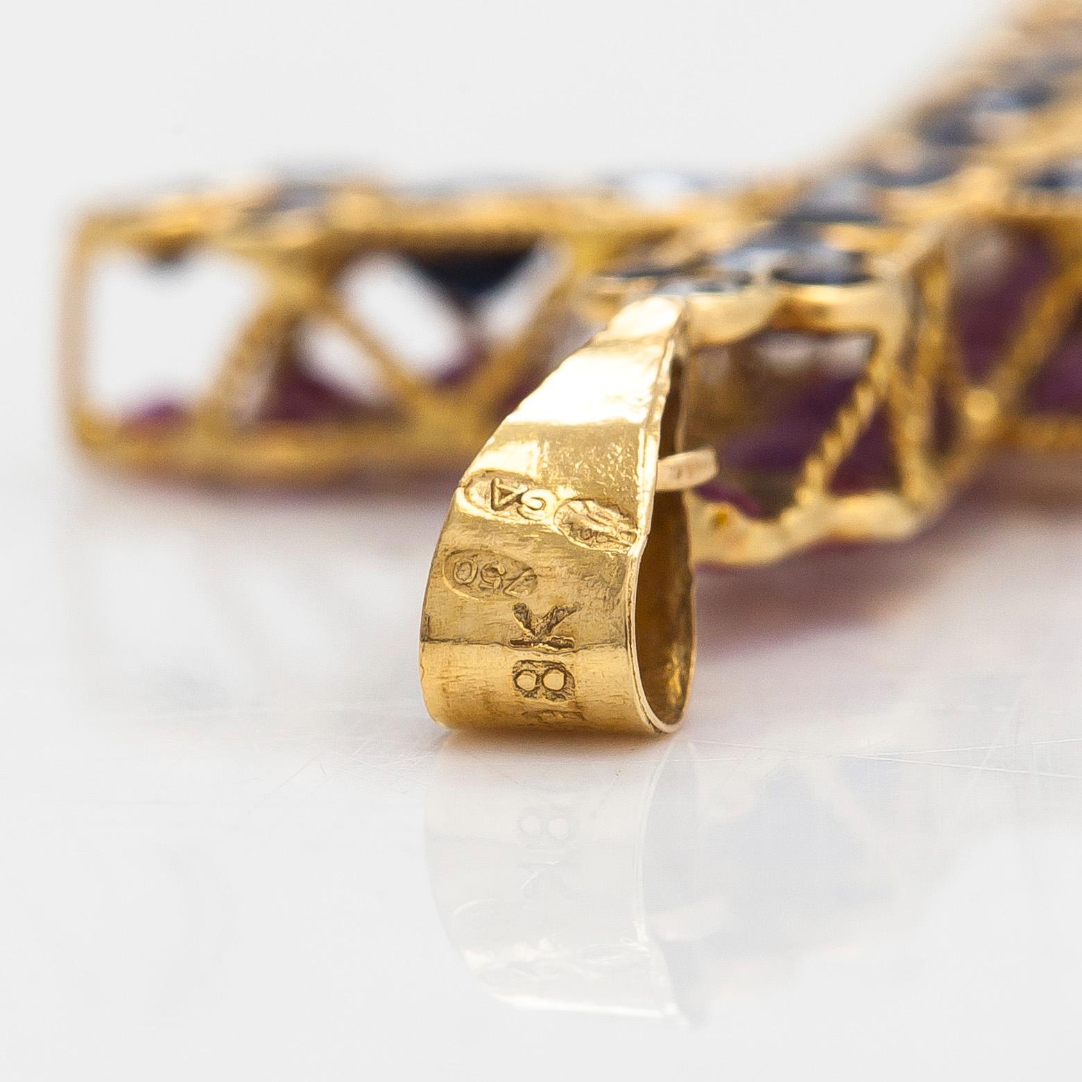 An 18K gold cross pendant with sapphires. Finnish import marks.