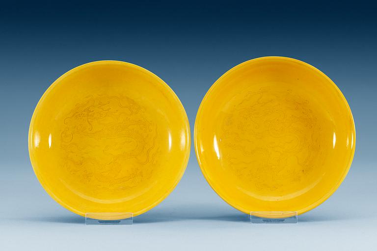 A pair of yellow-glazed incised dragon dishes, Qing dynasty with Qianlongs seal mark (1644-1912).