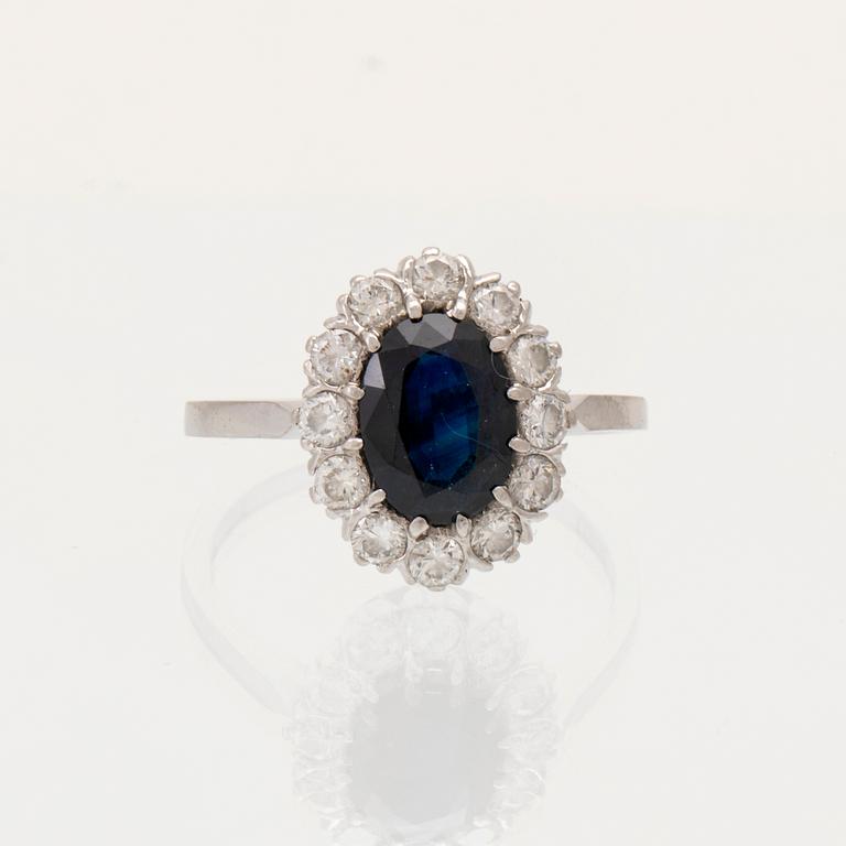 Ring 18K vitguld med oval fasetterad safir samt runda briljantslipade diamanter, Carl Hoff Helsingborg 1973.