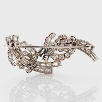 A platinum brooch set with baguette- and round brilliant-cut diamonds.