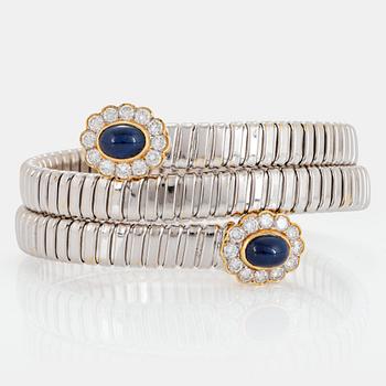 1036. An 18K gold bangle set with cabochon-cut sapphires and round brilliant-cut diamonds.