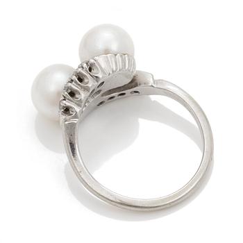 A cross-over ring of two cultured pearls with eight-cut diamonds.