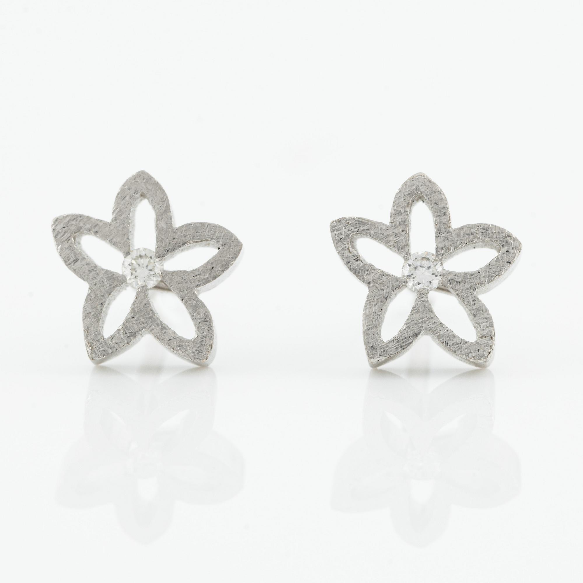 Ole Lynggard ett par örhängen i form av blommor.