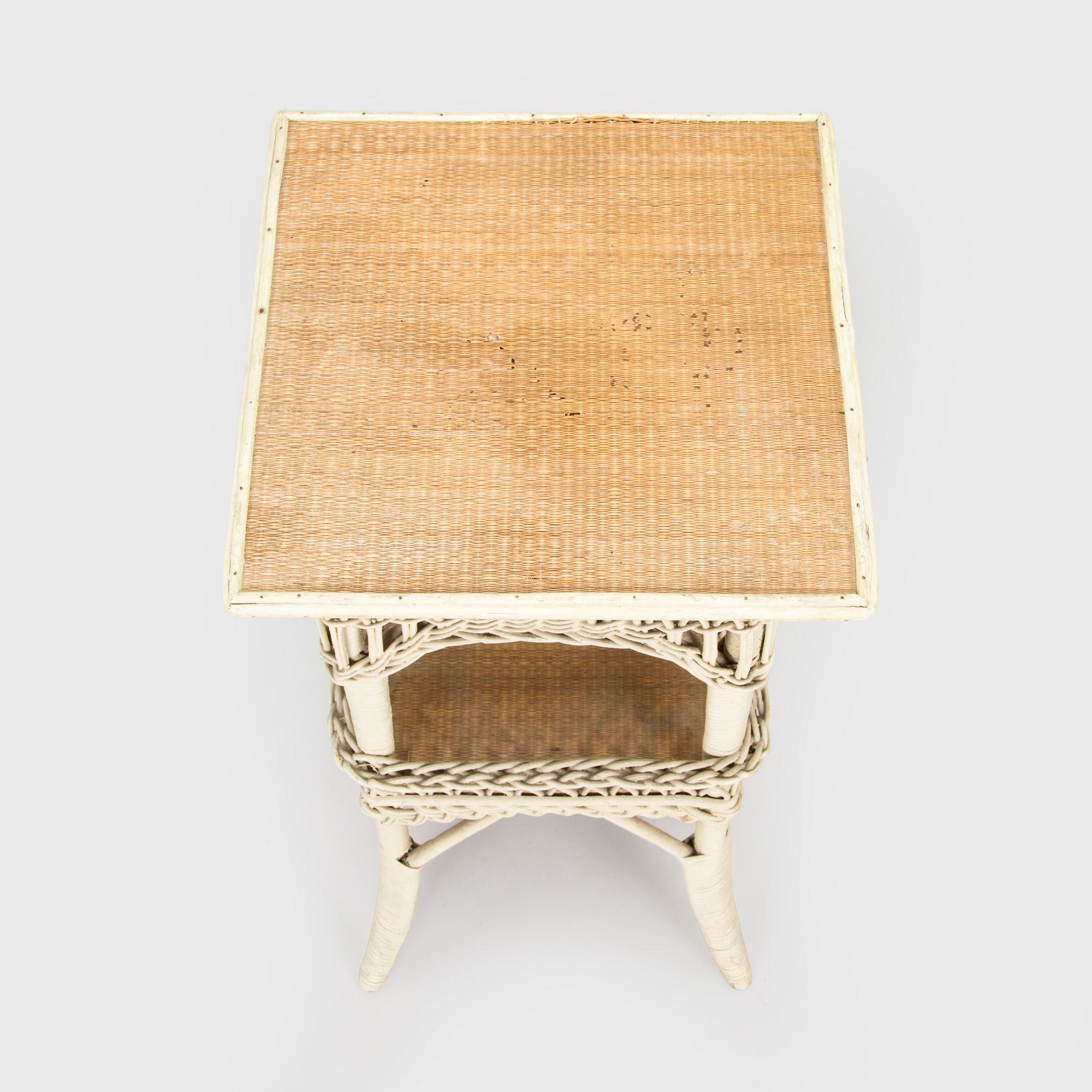 A mid-20th-century three-piece rattan furniture set including two armchairs, and a table.
