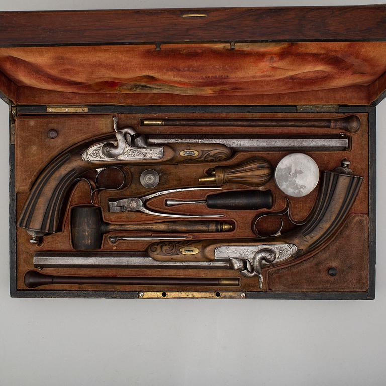 A pair of mid 19th century percussion pistols in a case marked Campagnac a Bordeaux.