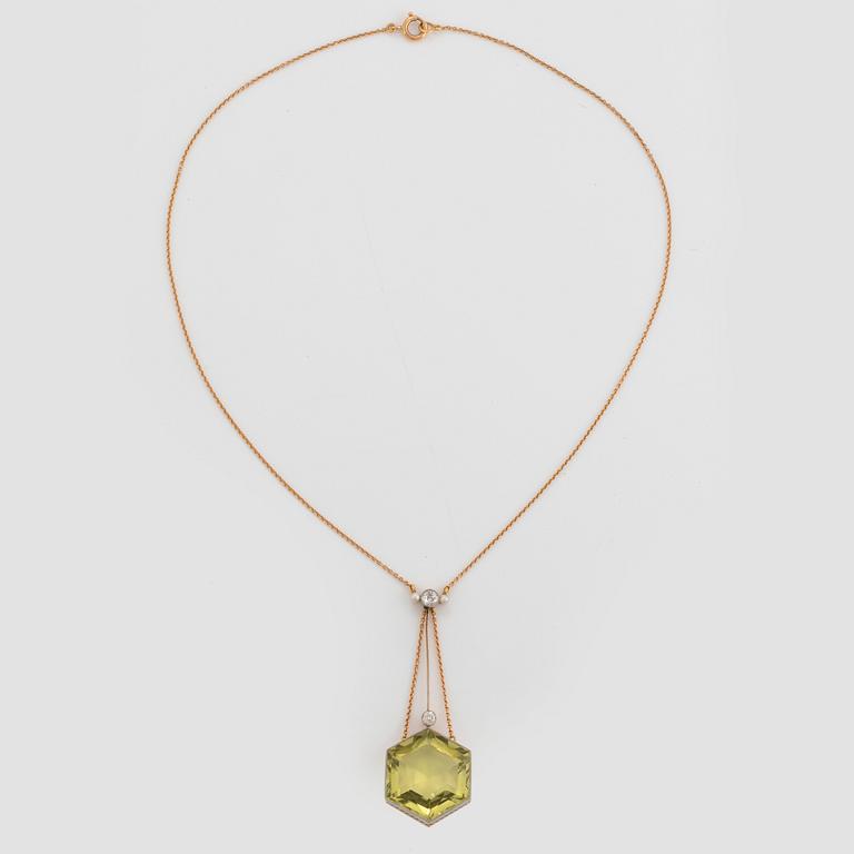 An 18K gold and platinum pendant set with a faceted beryl, old-cut diamonds and pearls.