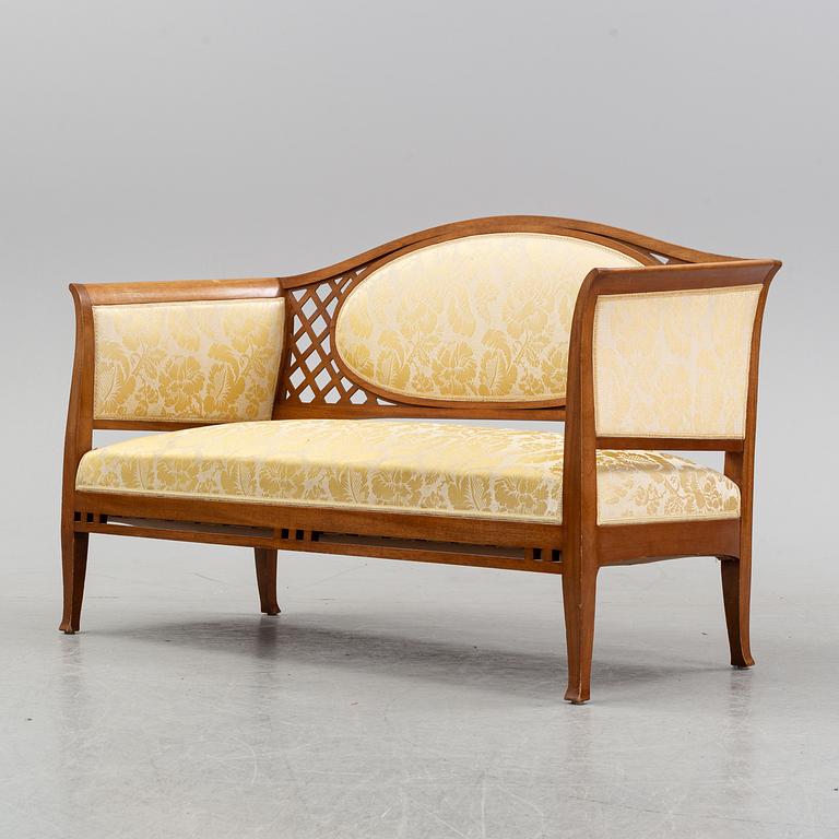 A mahogany sofa, with two armchairs and a round table, early 20th Century.