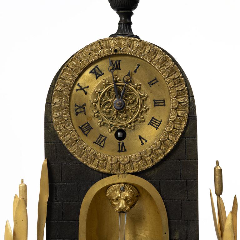 A French Charles X ormolu and patinated bronze mantel clock, ca 1820's.