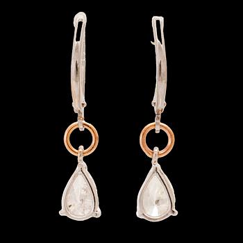 A pair of 18K white and rose gold earrings set with pear cut diamonds.