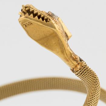 An 18K gold snake bracelet with an emerald and eight-cut diamonds.