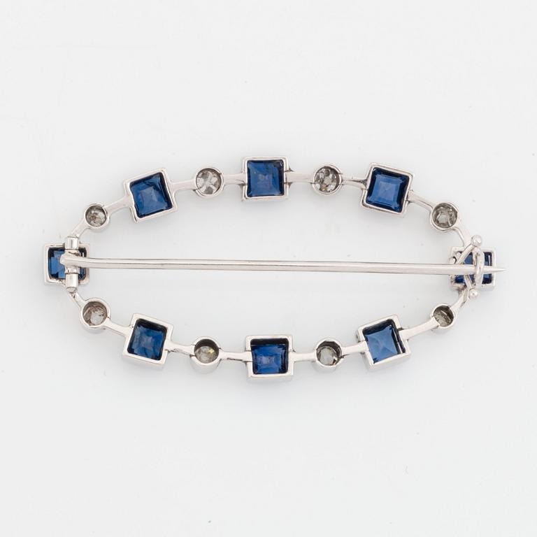 An 18K gold brooch set with faceted sapphires and old-cut diamonds.