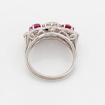 An 18K white gold ring set with faceted rubies and a round brilliant-cut diamond and eight-cut diamonds.